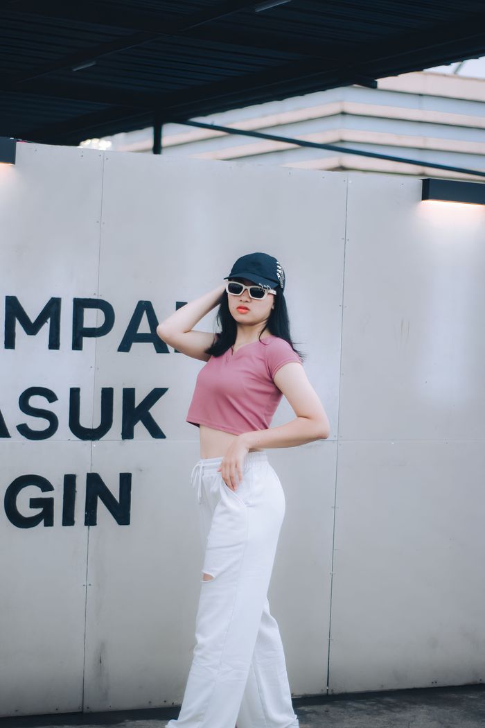 Fashionable woman wearing a crop top and sunglasses posing outdoors in Cimahi, Indonesia.
