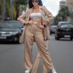 Confident woman in beige outfit posing on urban Nova Lima street.